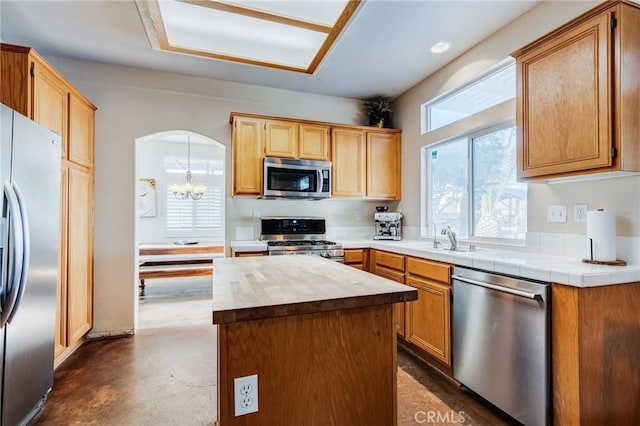 8961 Newcastle Ave, Hesperia, CA 92344 - kitchen with stainless steel appliances, arched walkways, a chandelier, concrete floors, and a sink