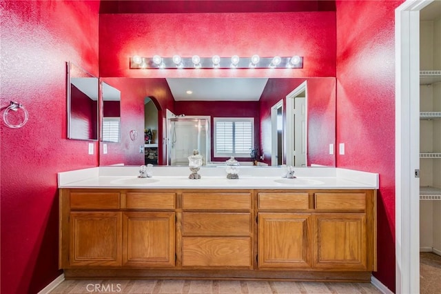 8961 Newcastle Ave, Hesperia, CA 92344 - full bathroom featuring a shower stall, double vanity, and baseboards
