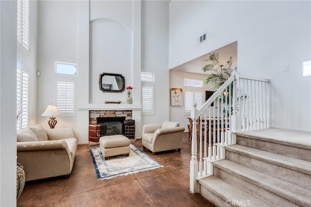 8961 Newcastle Ave, Hesperia, CA 92344 - living room featuring a towering ceiling, finished concrete flooring, stairway, healthy amount of natural light, and a fireplace