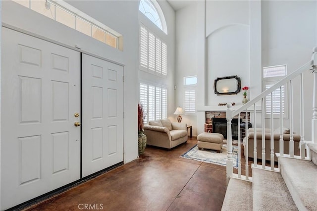 8961 Newcastle Ave, Hesperia, CA 92344 - entryway featuring a high ceiling, plenty of natural light, concrete floors, a fireplace, and stairs