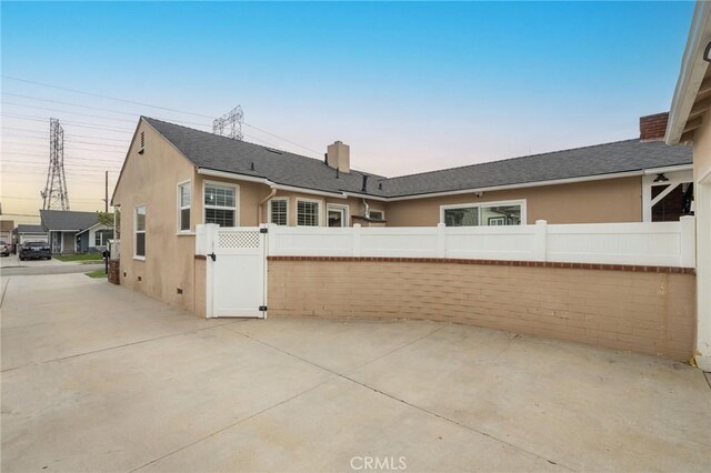6003 Eastbrook Ave, Lakewood, CA 90713 - rear view of property with a chimney, stucco siding, and a shingled roof