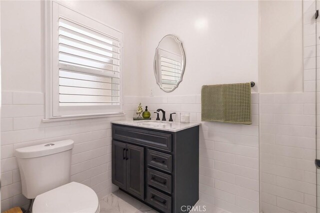 6003 Eastbrook Ave, Lakewood, CA 90713 - bathroom with tile walls, vanity, marble finish floors, and a wainscoted wall
