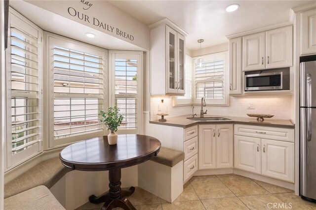 6003 Eastbrook Ave, Lakewood, CA 90713 - kitchen featuring appliances with stainless steel finishes, plenty of natural light, backsplash, glass insert cabinets, and recessed lighting