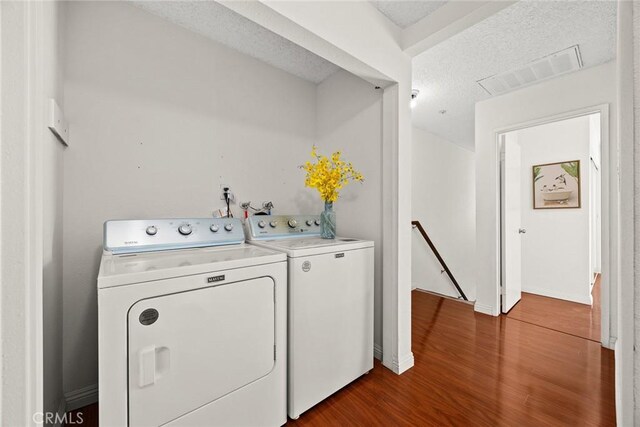 915 Carob Way Unit 2, Montebello, CA 90640 - laundry room featuring washing machine and clothes dryer, dark wood-type flooring, a textured ceiling, and baseboards