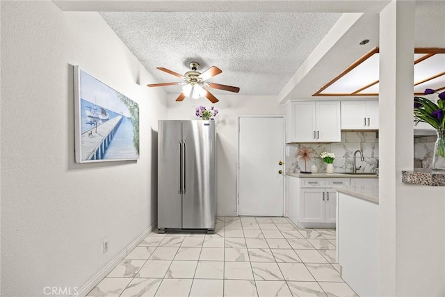 915 Carob Way Unit 2, Montebello, CA 90640 - kitchen featuring freestanding refrigerator, a ceiling fan, a sink, light marble finish flooring, and white cabinetry