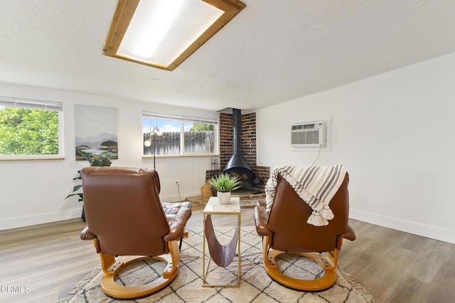 2791 Elizondo Ave, Simi Valley, CA 93065 - living area with a wood stove, plenty of natural light, a wall mounted AC, and wood finished floors