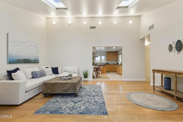 2791 Elizondo Ave, Simi Valley, CA 93065 - living area with a skylight, a high ceiling, and light wood finished floors