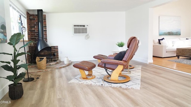 2791 Elizondo Ave, Simi Valley, CA 93065 - living area with wood finished floors, a wood stove, and an AC wall unit