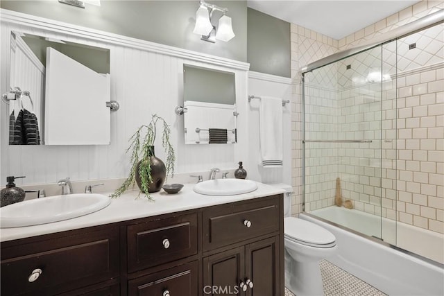 2482 New York Dr, Altadena, CA 91001 - bathroom with double vanity, combined bath / shower with glass door, toilet, tile patterned floors, and wainscoting