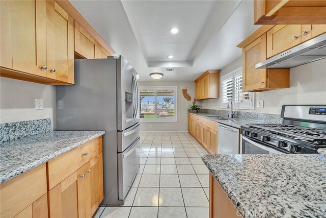 19545 Quicksilver Ln, Rowland Heights, CA 91748 - kitchen with appliances with stainless steel finishes, under cabinet range hood, a sink, light brown cabinets, and light stone counters