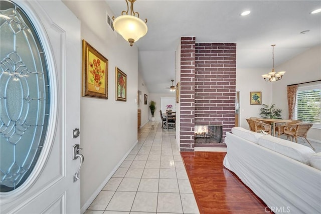 19545 Quicksilver Ln, Rowland Heights, CA 91748 - foyer entrance with vaulted ceiling, ceiling fan, light tile patterned flooring, a chandelier, and a fireplace