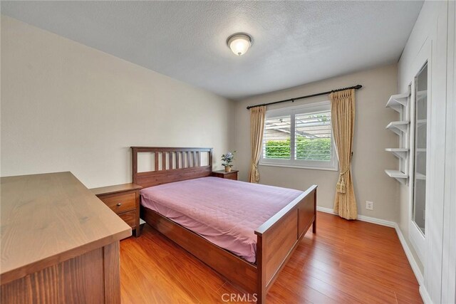 19545 Quicksilver Ln, Rowland Heights, CA 91748 - bedroom with light wood-type flooring, a textured ceiling, and baseboards