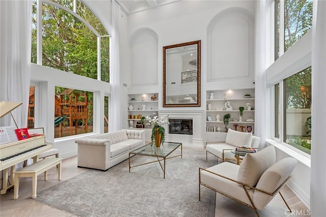 25548 Kingston Ct, Calabasas, CA 91302 - living area with healthy amount of natural light, a high ceiling, built in features, and a glass covered fireplace