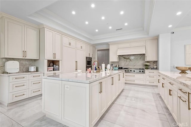 25548 Kingston Ct, Calabasas, CA 91302 - kitchen featuring crown molding, appliances with stainless steel finishes, a tray ceiling, light marble finish flooring, and backsplash