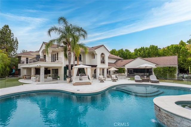 25548 Kingston Ct, Calabasas, CA 91302 - rear view of property with a patio area, a balcony, stucco siding, a pool with connected hot tub, and a tiled roof