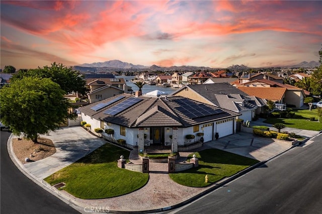 18016 Mariner Dr, Victorville, CA 92395 - ranch-style house with concrete driveway, an attached garage, a residential view, and roof mounted solar panels