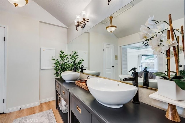 18016 Mariner Dr, Victorville, CA 92395 - bathroom with lofted ceiling, wood finished floors, double vanity, and baseboards