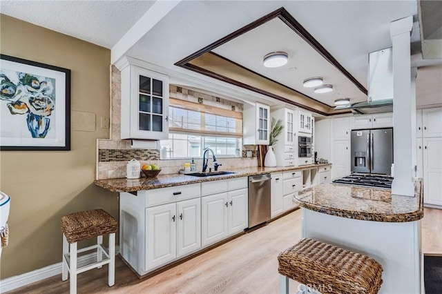 18016 Mariner Dr, Victorville, CA 92395 - kitchen featuring stainless steel appliances, backsplash, a sink, dark stone counters, and white cabinetry