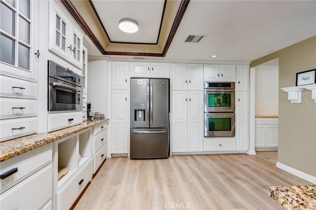 18016 Mariner Dr, Victorville, CA 92395 - kitchen featuring appliances with stainless steel finishes, light wood-type flooring, white cabinetry, light stone countertops, and glass insert cabinets