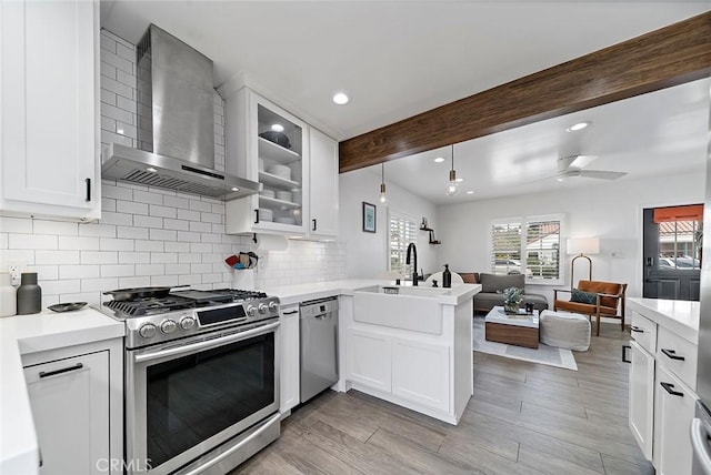 4218 E 3rd St, Long Beach, CA 90814 - kitchen with wall chimney exhaust hood, stainless steel appliances, open floor plan, a peninsula, and a sink