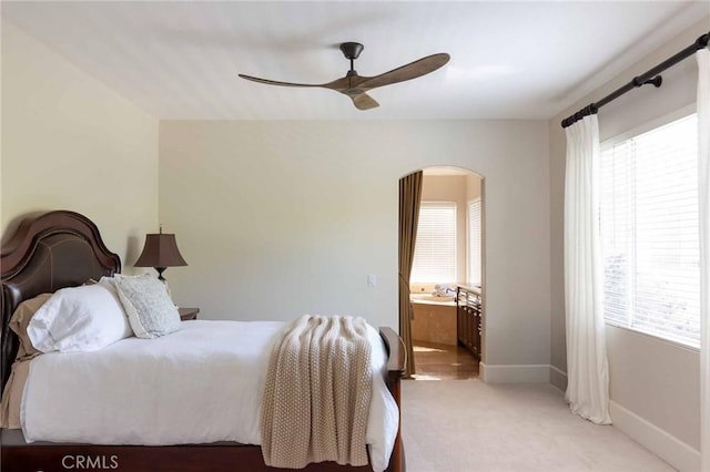 23317 Cuestport Dr, Valencia, CA 91354 - bedroom with arched walkways, light carpet, baseboards, a ceiling fan, and ensuite bath