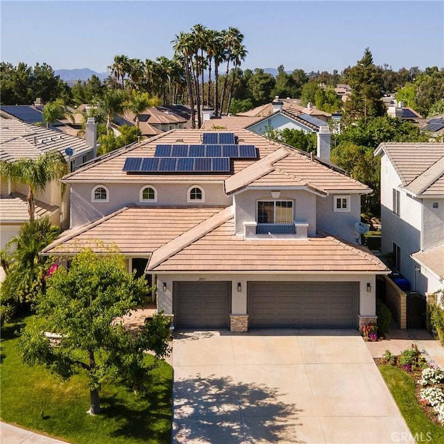 23317 Cuestport Dr, Valencia, CA 91354 - mediterranean / spanish home featuring concrete driveway, solar panels, stucco siding, a garage, and stone siding
