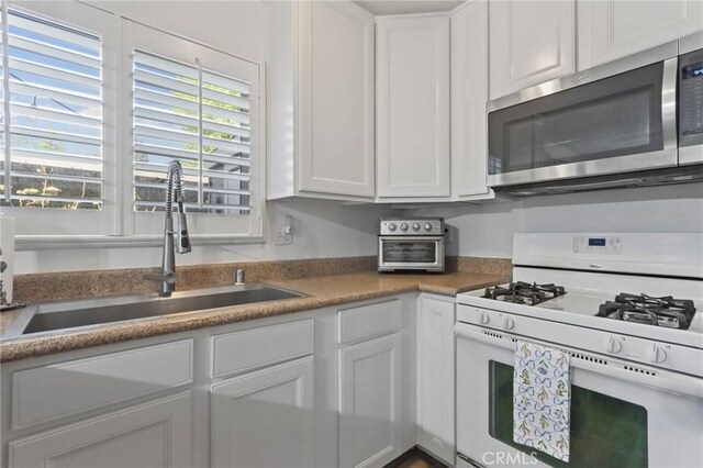 3175 Saginaw Ct, Pleasanton, CA 94588 - kitchen with white range with gas stovetop, stainless steel microwave, a sink, and white cabinetry