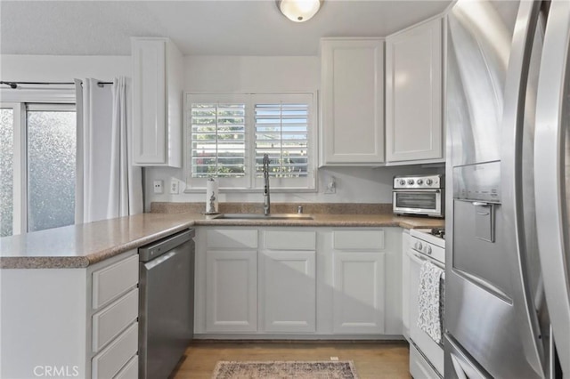 3175 Saginaw Ct, Pleasanton, CA 94588 - kitchen with appliances with stainless steel finishes, a sink, white cabinetry, and a peninsula