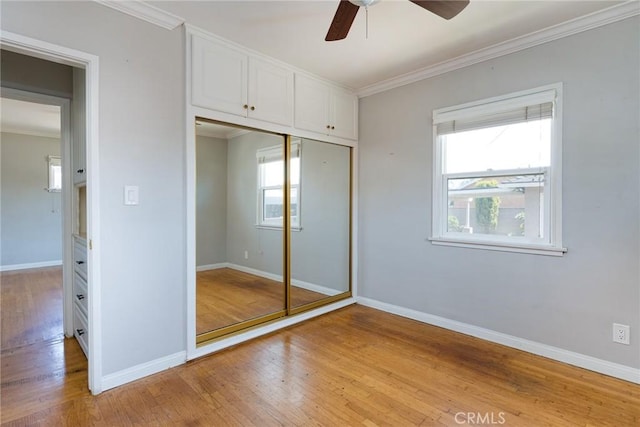 1032 W R St, Wilmington, CA 90744 - unfurnished bedroom featuring light wood-type flooring, crown molding, multiple windows, baseboards, and a closet