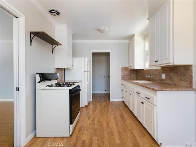 1032 W R St, Wilmington, CA 90744 - kitchen with gas range, open shelves, tasteful backsplash, white cabinetry, and light wood-style floors