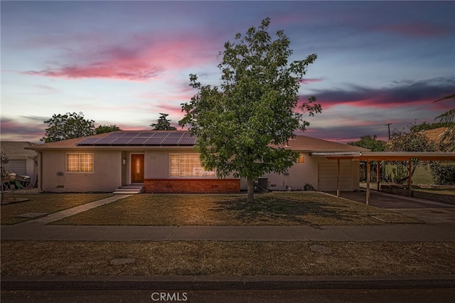 412 2nd St, Orland, CA 95963 - view of front of property with a carport, stucco siding, solar panels, and driveway