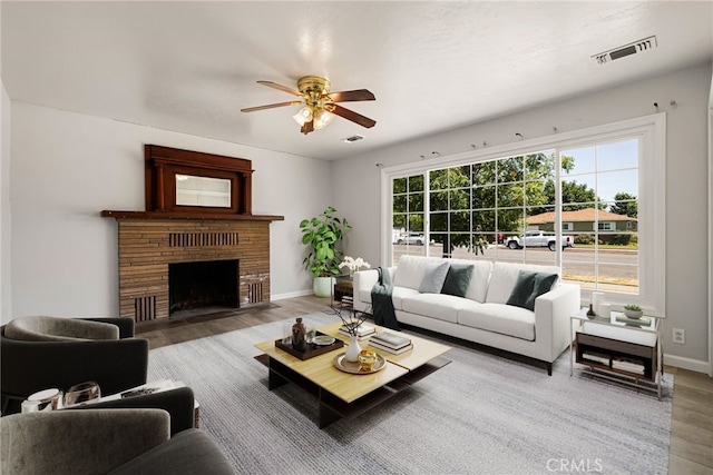 412 2nd St, Orland, CA 95963 - living area featuring wood finished floors, ceiling fan, baseboards, and a fireplace with flush hearth