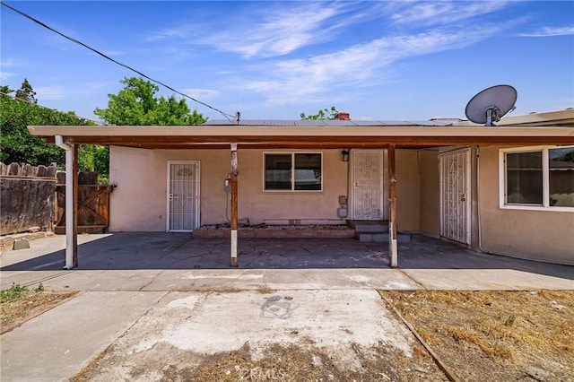 412 2nd St, Orland, CA 95963 - view of front of property with stucco siding, roof mounted solar panels, and a gate