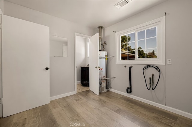 412 2nd St, Orland, CA 95963 - washroom featuring secured water heater, wood finished floors, and baseboards
