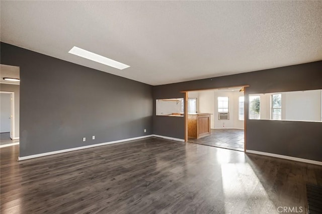 29247 Allan St, Lake Elsinore, CA 92532 - empty room featuring dark wood-type flooring, a skylight, vaulted ceiling, cooling unit, and a textured ceiling
