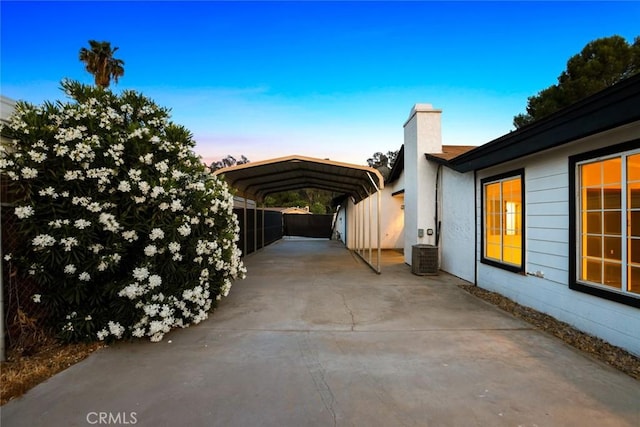 29247 Allan St, Lake Elsinore, CA 92532 - view of side of property featuring a detached carport, a chimney, driveway, and central AC unit