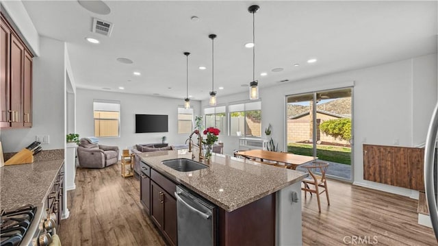 36434 Geranium Dr, Lake Elsinore, CA 92532 - kitchen with appliances with stainless steel finishes, a sink, wood finished floors, open floor plan, and light stone countertops