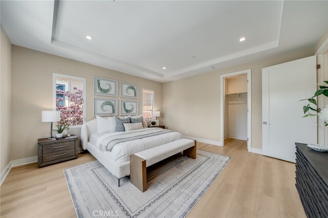 127 Toretta, Irvine, CA 92602 - bedroom with a tray ceiling, light wood finished floors, a walk in closet, baseboards, and recessed lighting