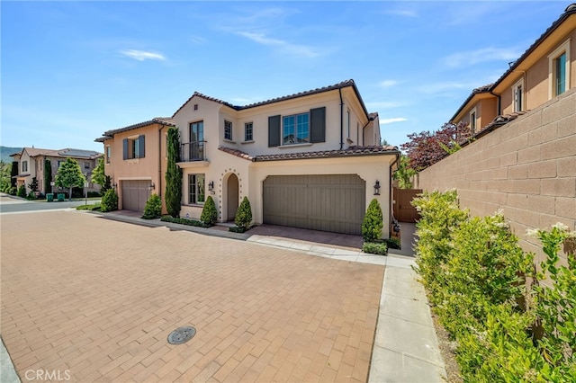 127 Toretta, Irvine, CA 92602 - mediterranean / spanish-style home with stucco siding, a tiled roof, decorative driveway, and an attached garage