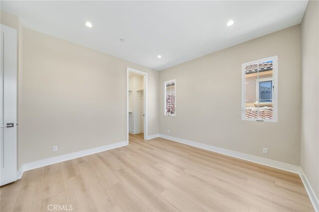127 Toretta, Irvine, CA 92602 - unfurnished bedroom with light wood-type flooring, a walk in closet, baseboards, recessed lighting, and a closet