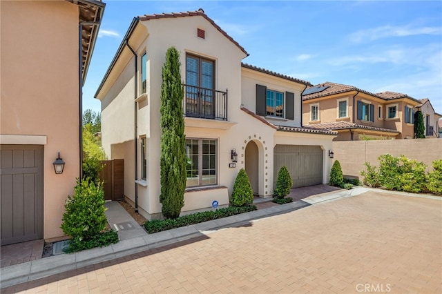 127 Toretta, Irvine, CA 92602 - view of front facade with a balcony, stucco siding, a garage, decorative driveway, and a tiled roof