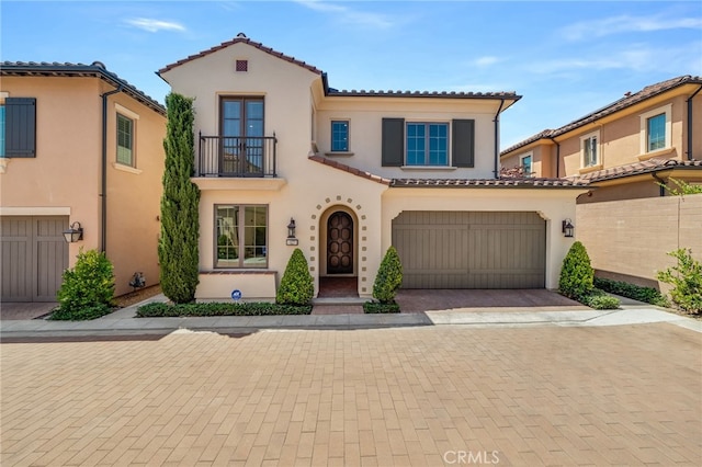 127 Toretta, Irvine, CA 92602 - mediterranean / spanish house with a balcony, a tiled roof, stucco siding, an attached garage, and decorative driveway