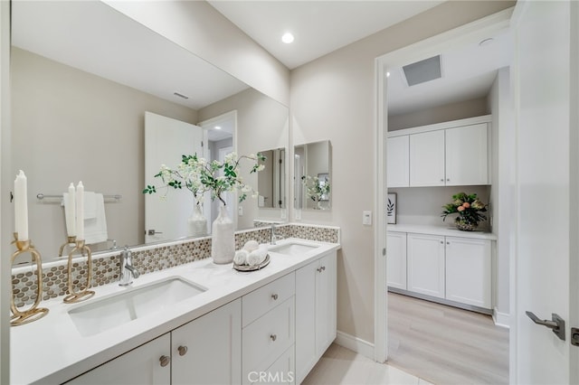 127 Toretta, Irvine, CA 92602 - bathroom featuring double vanity, recessed lighting, wood finished floors, baseboards, and decorative backsplash
