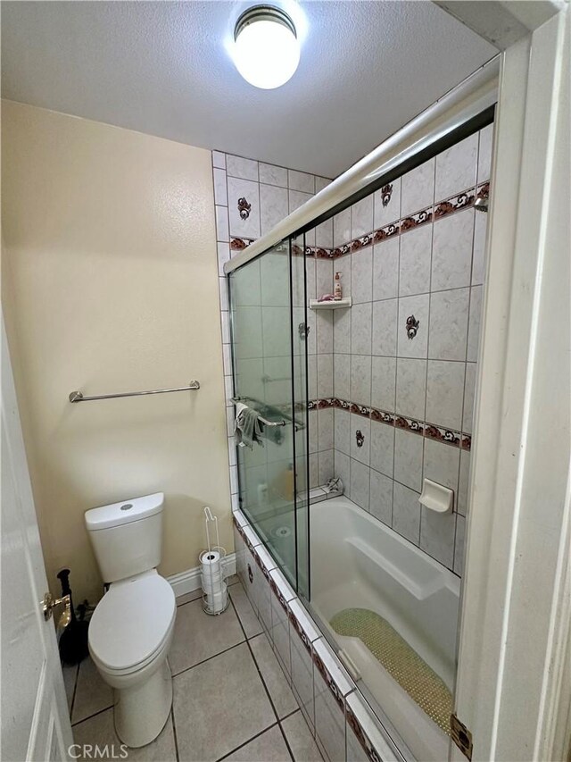 42500 20th St W, Lancaster, CA 93534 - full bathroom featuring tiled shower / bath combo, toilet, tile patterned flooring, a textured ceiling, and baseboards