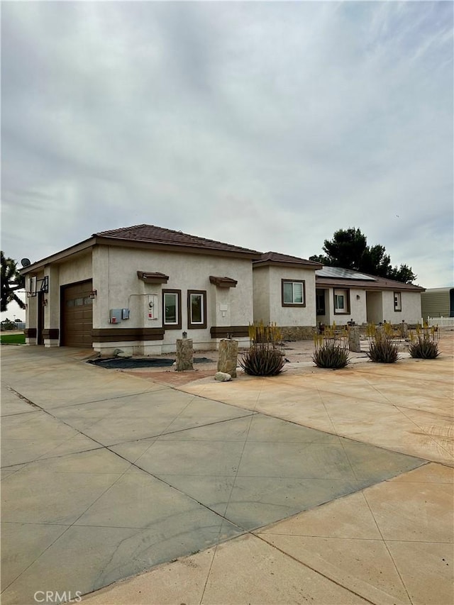 42500 20th St W, Lancaster, CA 93534 - view of front facade featuring stucco siding, an attached garage, and driveway