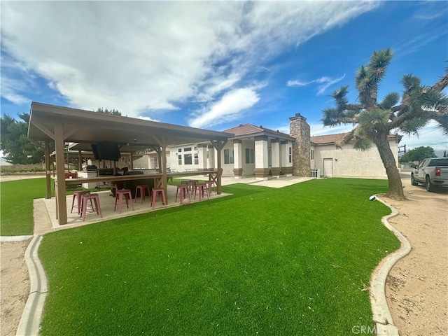 42500 20th St W, Lancaster, CA 93534 - rear view of house featuring a yard, a patio area, and a chimney