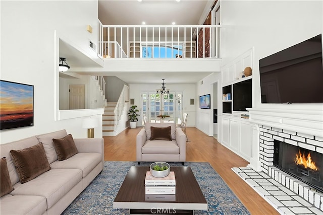 28918 Lillyglen Dr, Canyon Country, CA 91387 - living area with stairway, light wood-style flooring, a towering ceiling, and a lit fireplace