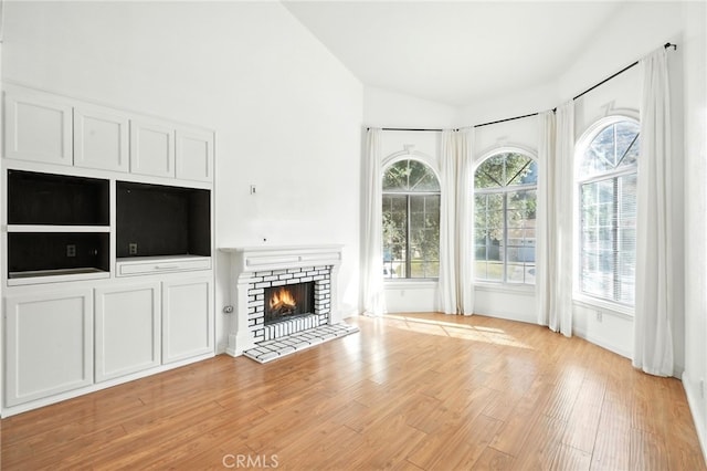 28918 Lillyglen Dr, Canyon Country, CA 91387 - unfurnished living room with vaulted ceiling, light wood-type flooring, and a fireplace