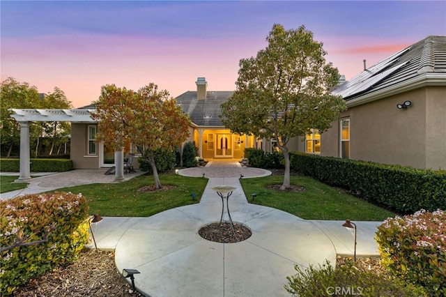 19103 Green Oaks Rd, Yorba Linda, CA 92886 - view of front of home featuring a pergola, stucco siding, a front lawn, and roof mounted solar panels