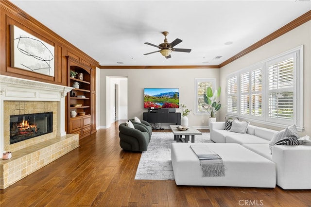 19103 Green Oaks Rd, Yorba Linda, CA 92886 - living area featuring a ceiling fan, dark wood-type flooring, a glass covered fireplace, built in features, and crown molding